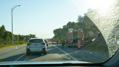Mont-Tremblant QC Canada - 22.09.2024: The fire truck is parked on the side of the road with its lights flashing, while several firefighters gather around the truck, engaged in conversation about their next response to an emergency.