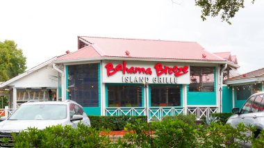 Orlando FL, United States - December 31, 2024: Exterior of Bahama Breeze Island Grille showcasing vibrant colors and tropical ambiance with lush greenery