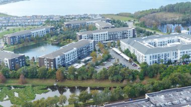 Orlando FL, United States - December 31, 2024: Aerial perspective showcasing contemporary apartment buildings with green landscaping and tranquil water features
