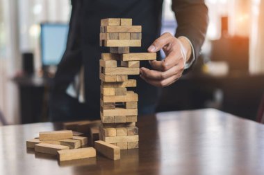 Ahşap blok çekme işadamı challenge oyun Bina İnşaatı oynarken ellerini planı korumak ve denetimi risk şekli için proje tehlike kule başarısız.