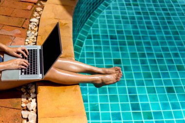 Kadın bikini Yüzme Havuzu resort Edge, yan görünüm, dizüstü bilgisayar boş ekran kullanma