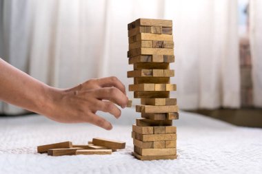 Genç adam ahşap blok çekerek başarısız evde tower binasında ve örtüsü değiştirmek, seçim iş tehlikeli proje planı başarısızlık inşaat kavramı riske.