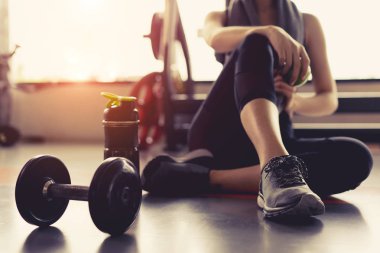 Kadın egzersiz egzersiz jimnastik salonu fitness son dakika içinde dinlenmek sonra eğitim spor dumbbell ve protein ile elma meyve sallamak şişe yaşam sağlıklı vücut geliştirme holding.