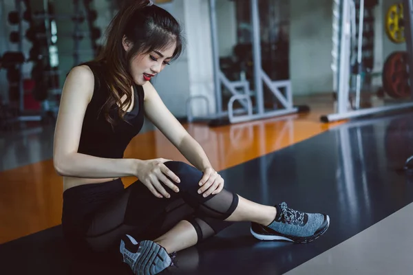 Woman doing sport exercise injury knee accident at gym fitness