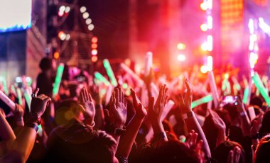Bel soğukluğu veya eller yukarı etkisi Müzik Festivali arka görünümünde parlak projektör ile eller siluet yükselterek konser sahne ışıkları ve insanlar hayran kitlesi de kalabalık