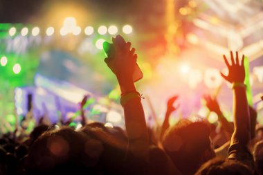Kalabalık ellerinde Müzik Festivali dikiz spot parlak etkisi ile yükselterek konser sahne ışıkları ve insanlar fan seyirci siluet Kaldır ellerini