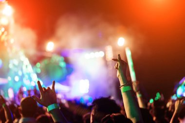 Kalabalık ellerinde Müzik Festivali dikiz spot parlak etkisi ile yükselterek severler konser sahne ışıkları ve insanlar fan seyirci siluet Kaldır ellerini