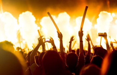 Kalabalık eller ya da Müzik Festivali arka görünümünde holding spot parlak etkisi ve duman ile ışıklı çubuk yetiştirme konser sahne ışıkları ve insanlar fan seyirci silueti
