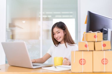 Genç Asyalı kadın serbest meslek küçük işletme evde çalışma dizüstü bilgisayar, Not, kahve office özel, ambalaj teslim online pazar üzerinde satınalma siparişleri için müşteri.