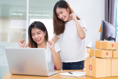 Genç Asyalı kız birlikte ekip çalışması freelancer küçük işletme özel evde çalışma dizüstü bilgisayar, Not, telefon office, teslimat online pazar için müşteri siparişlerini denetleme satın alma ambalaj ve paketleme.