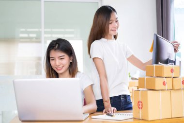 Genç Asyalı kız birlikte ekip çalışması freelancer küçük işletme özel evde çalışma dizüstü bilgisayar, Not, telefon office, teslimat online pazar için müşteri siparişlerini denetleme satın alma ambalaj ve paketleme.