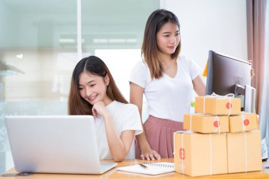 Genç Asyalı kız birlikte ekip çalışması freelancer iş evde çalışma dizüstü bilgisayar, Not, mobil, teslimat online pazar için müşteri siparişlerini denetleme satın alma ambalaj ve paketleme office özel.