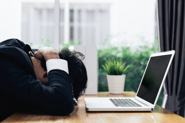 Businessman failure project plan deadline serious emotion and depression or deadline at office room with laptop computer report on working table