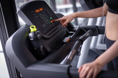 Closeup push ince ve firma sağlıklı yaşam tarzı için makine aerobik ile kilo kaybı alarak kadının fitness spor salonunda egzersiz koşu bandı kardiyo çalışan egzersiz başlatmak.