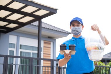 Maskeli bir teslimatçı, süpermarketten müşteri hizmetlerine çevrimiçi alışveriş yapan plastik poşetler dağıtıyor. Coronavirus 19 yeni normal yaşam tarzına kavuştuğunda market alışverişini yapıyor..