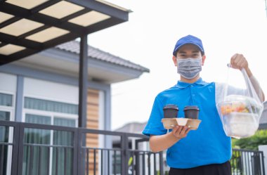 Maskeli bir teslimatçı, süpermarketten müşteri hizmetlerine çevrimiçi alışveriş yapan plastik poşetler dağıtıyor. Coronavirus 19 yeni normal yaşam tarzına kavuştuğunda market alışverişini yapıyor..