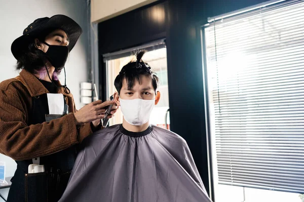Asia Barber Shop Hair cut queueing customer\'s wearing face mask prevention business reopening after coronavirus lockdown, Men\'s hairstyling and new normal lifestyle concept.