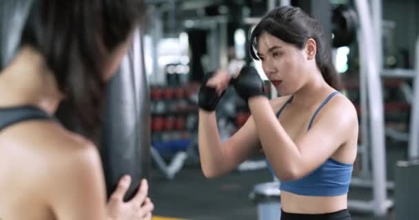肥胖的亚洲年轻女子与教练一起训练带腕带的拳击手 与健身馆的伙伴一起练习拳击或运动 养成健康的生活方式和自我防卫的观念 — 图库视频影像