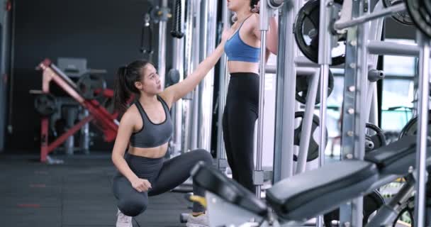 여성은 대장장이 기계에 바벨과 체육관에서 운동을 트레이너가 보디빌딩 선수의 훈련을 — 비디오