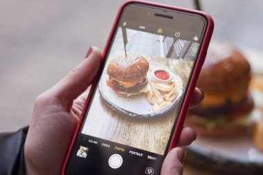 Kız bir hamburger resmini alıyor