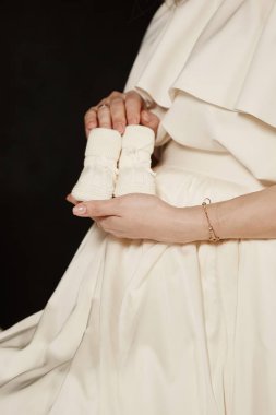 Pregnang kadınla el küçük bebek patikleri