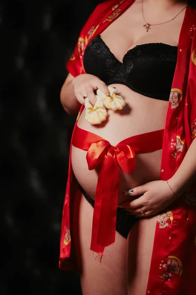 Pregnang 妇女与小婴孩鞋子在手 — 图库照片