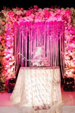 Düğün dekorasyon. Düğün pastası, mum, ışık ve çiçekler ile tablo.