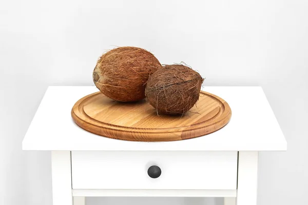 Hausgemachte Kokosprodukte auf weißem Holztischhintergrund. ganze Kokosnuss auf weißem Tisch. Tropisches Sommerkonzept. — Stockfoto