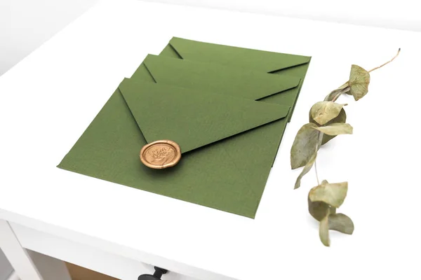 Envelope verde com cartão de grife e selo em um fundo branco. Envelope com selo — Fotografia de Stock