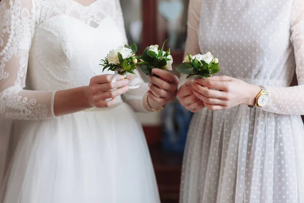 Belo boutonier de casamento com flores brancas e verdes nas mãos da noiva e namoradas em vestimenta branca — Fotografia de Stock