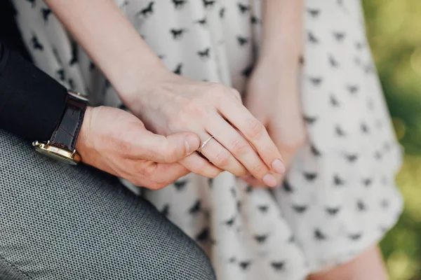 Doi îndrăgostiţi, un cuplu, un băiat şi o fată se ţin de mână. Fata de pe mâna ei este un inel de nuntă. conceptul de iubire — Fotografie, imagine de stoc