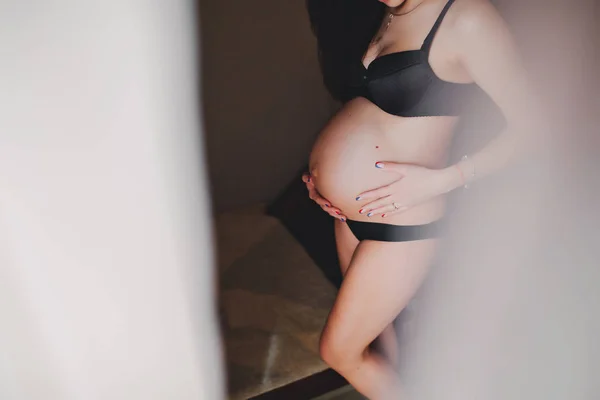 Väntar på bebis. Gravid kvinna som står och händer omfamnar en rund mage, mage. närbild. Moderskap koncept. — Stockfoto