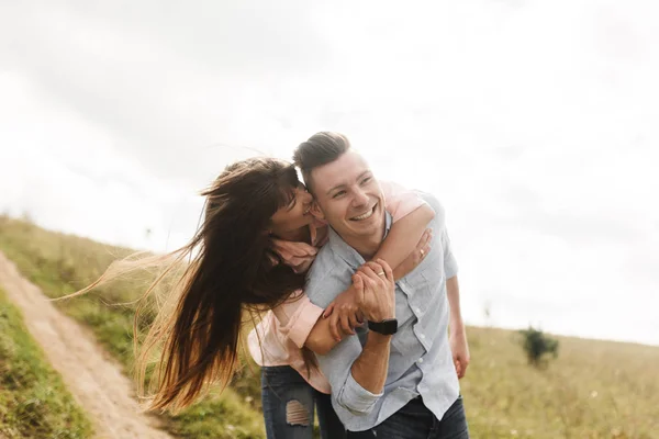 Amar a la joven pareja besándose y abrazándose al aire libre. Amor y ternura, citas, romance, familia, concepto de aniversario . — Foto de Stock