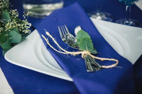 Decoração. Detalhes. Composição. Decorações de casamento em tons azuis. Na mesa de madeira na floresta há uma vegetação, talheres, eucalipto — Fotografia de Stock