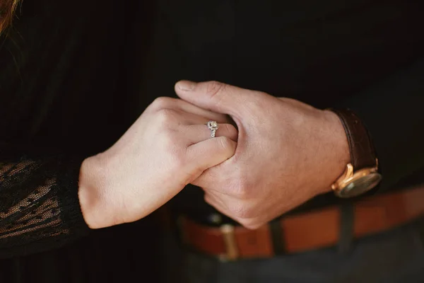 Dos amantes, una pareja, un chico y una chica están tomados de la mano. La chica de su mano es un anillo de bodas. el concepto de amor — Foto de Stock