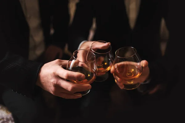 Üzleti megbeszélés. A férfiak whiskyt tartanak a kezükben. Férfi Párt. Kéz egy kis alkohollal — Stock Fotó