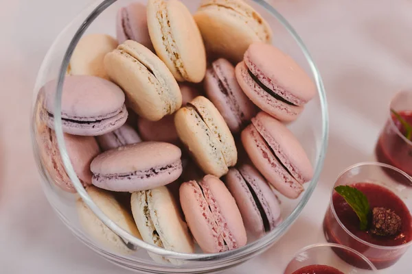 Bunte Macarons stehen in runden transparenten Gewicht als Teil der Schokoriegel Sweet Table — Stockfoto