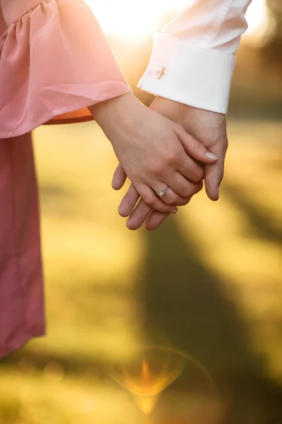Jovem casal de mãos dadas no anel do braço. Vista Close Up — Fotografia de Stock