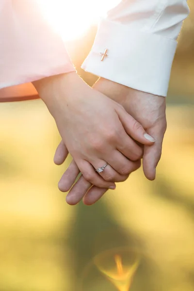 Giovane coppia che si tiene per mano l'anello del braccio. Vista da vicino — Foto Stock