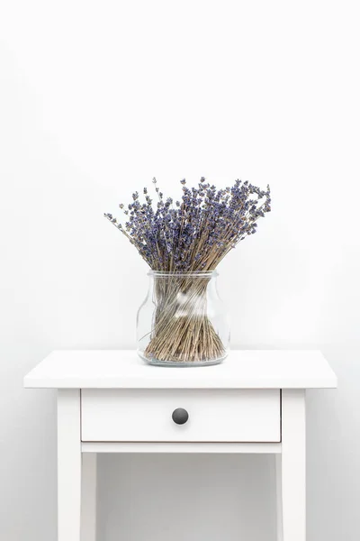 Flores de lavanda em vaso de vidro, fundo de madeira branco, conceito de spa, aromaterapia. Flores de lavanda de perto — Fotografia de Stock