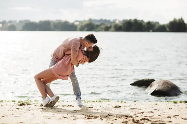 Loving ungt par kyssas och kramas i utomhus. Kärlek och ömhet, dating, romantik, familj, årsdagen koncept. — Stockfoto