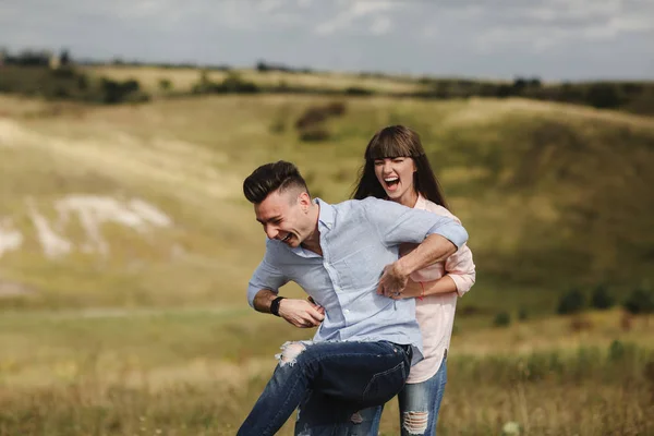 Pareja joven loca emocionalmente divertirse, besar y abrazar al aire libre. Amor y ternura, romance, familia, emociones, diversión. divertirse juntos —  Fotos de Stock