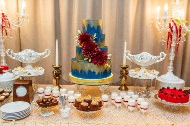 Çikolata. Mavi Düğün pastası çöller, çilek tartı ile cupcakes şenlikli tablonun çiçek durarak dekore edilmiştir. Düğün.