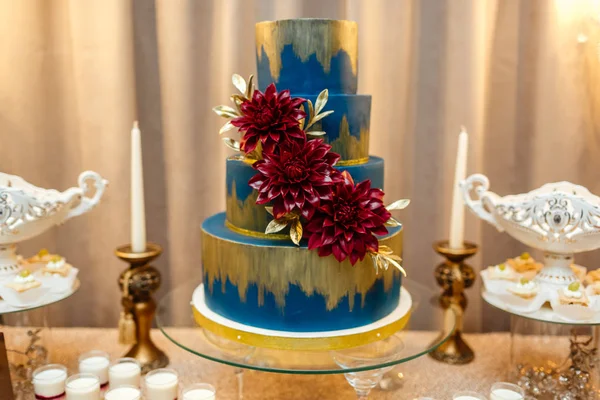 Tyčinku. modré svatební dort zdobený květy postavení svátečního stolu s pouští, jahodový tartlet a koláčky. Svatba. — Stock fotografie