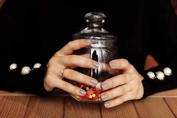 Wanita muda menunjukkan botol obat. Kapsul berwarna. kapsul obat yang berbeda tumpah dari gelas. konsep obat — Stok Foto
