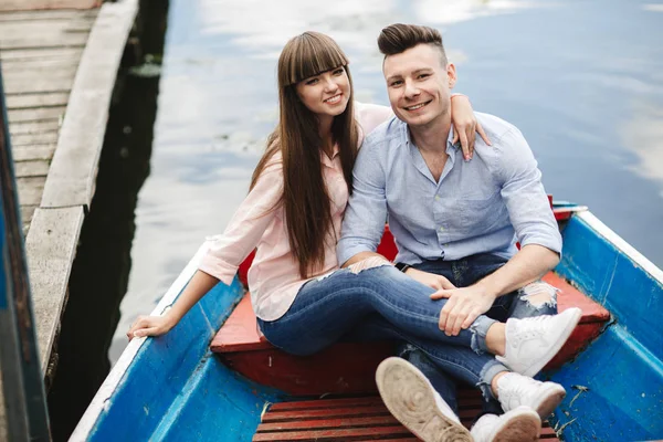 A couple riding a blue boat on a lake. romance. emotional couple. funny and in love