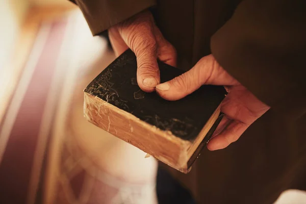Een boek in de handen van een oude man. weinig Bijbel — Stockfoto