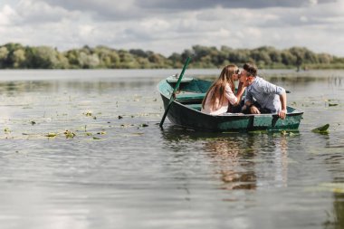 Sadece rahatlatıcı. Güzel genç bir tekne kürek süre zevk romantik Tarih Çift. Sevgi dolu bir çift yeşil bir tekne sürme sırasında bir gölde dinlenme. romantizm.