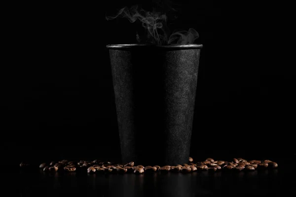 Czarne szkło gorącej kawy z rozrzuconych ziaren kawy na czarnym tle. szczelnie-do góry — Zdjęcie stockowe