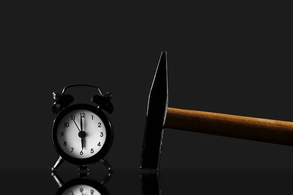 Despierta con un martillo sobre un fondo negro. Reloj despertador negro de estilo antiguo aislado —  Fotos de Stock